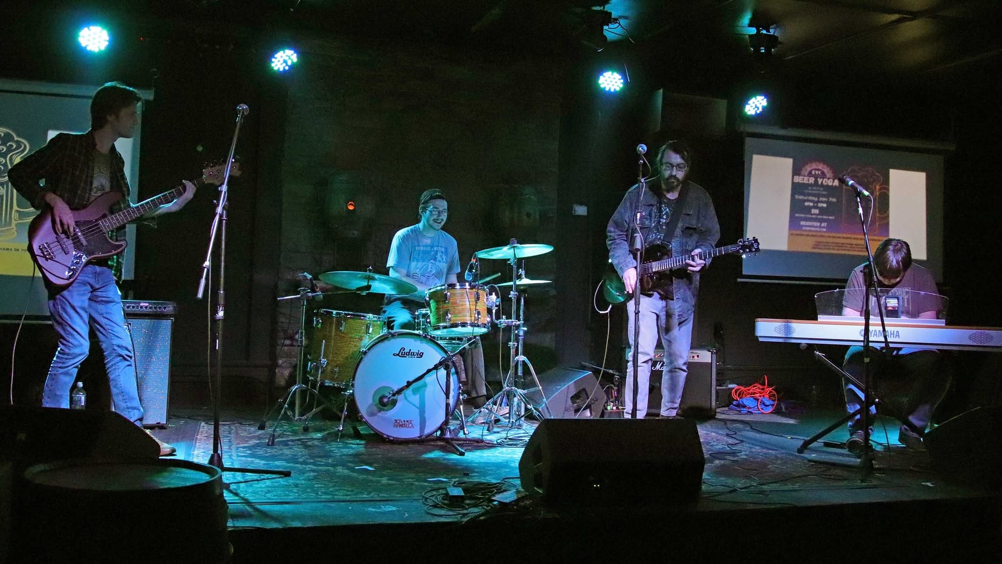 Full band performing on stage with green lighting