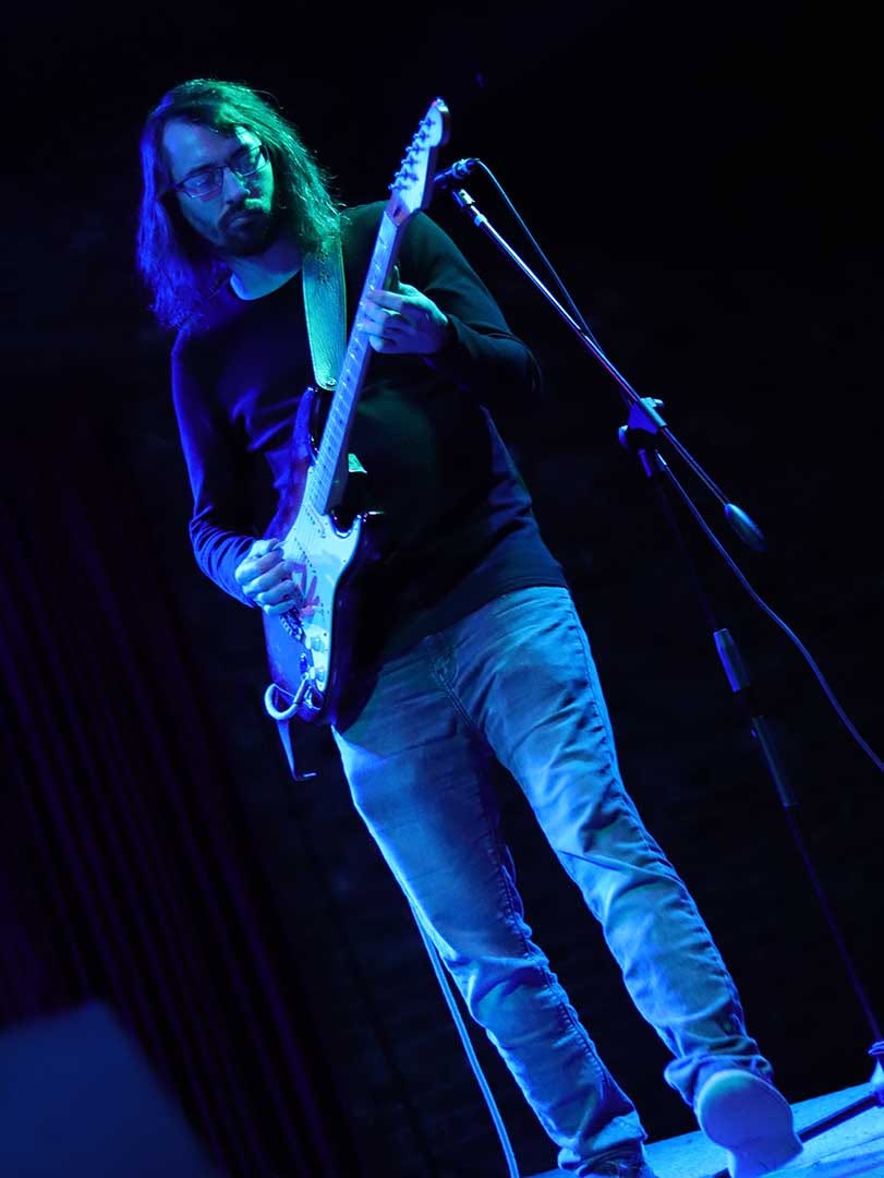 Cade Howard performing under blue stage lighting