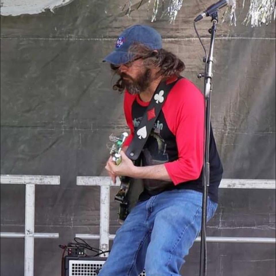 Cade Howard playing guitar at an outdoor festival